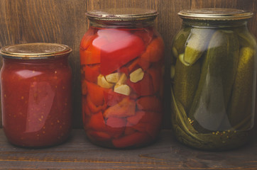 preserved foods in banks in rural style. On a wooden background/preserved foods in banks in rural style