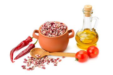 beans in a ceramic pot, cooking oil and vegetables isolated on w