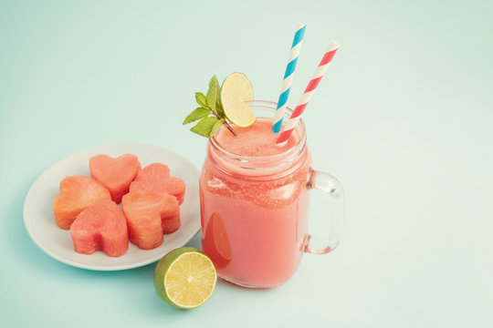 Watermelon Smoothie In Mason Jar Decorated With Lime, Mint, Straws