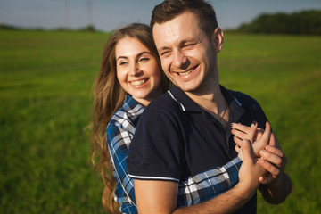 happy and enamored teenagers embracing in a field