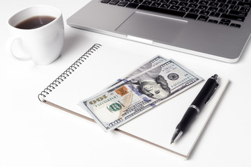Cup With Coffee And Notebook On Which Lie Two Hundred Dollars Ne