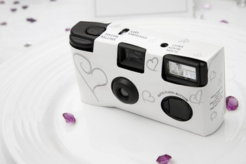 Disposable white wedding camera on a wedding table.