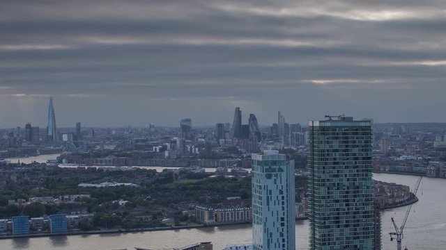 a sunset timelapse of the city of london skyscapers, zoomed in from a high vantage point far away. amazing sunrays are captured during this scene