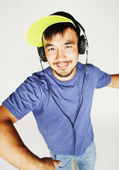 young asian man in hat and headphones listening music on white b