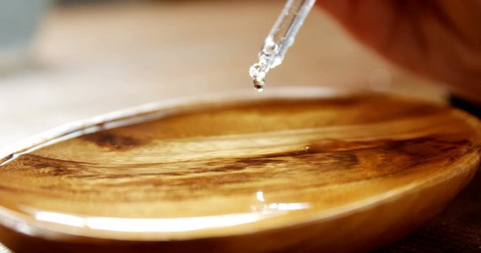 Close-up of dropper pouring water drop on a bowl 4k