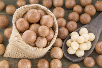 Organic Macadamia nut on wooden table (Macadamia integrifolia)