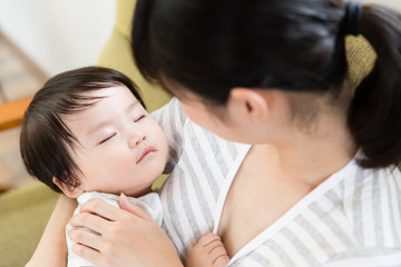 asian mother and baby relaxing on the sofa