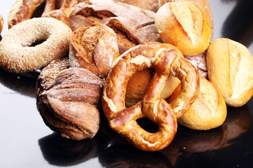 Different kinds of bread and bread rolls on board from above. Ki