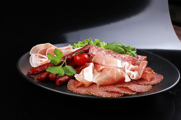 Food tray with delicious salami, pieces of sliced ham, sausage,