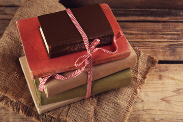 Old books tied in ribbon on wooden background