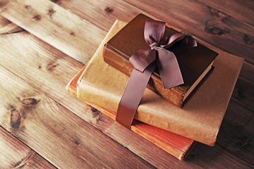 Old books tied in ribbon on wooden background