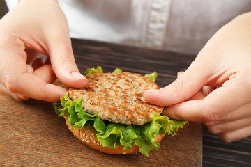 Female hands cooking tasty burger
