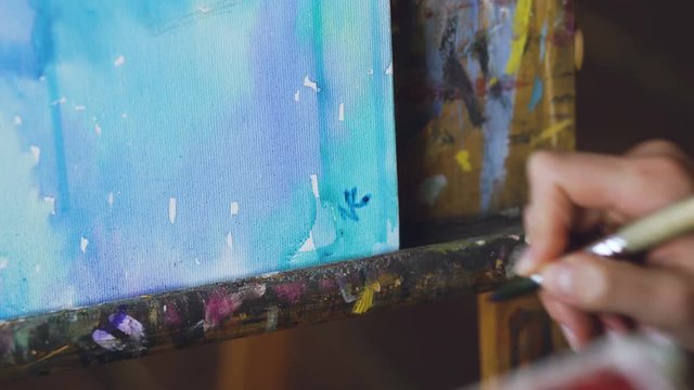 Young woman artist draw pictrure with watercolor paints and write her signature on finish closeup