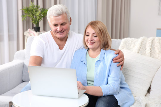 Grandparents using laptop at home