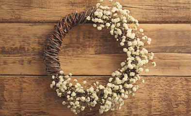 Floral wreath with beautiful flowers on wooden background