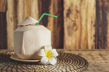 Coconut with plumeria on wooden background © Africa Studio
