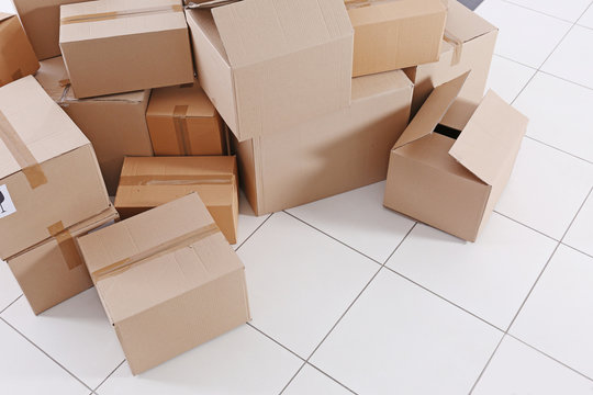 House move concept. Carton boxes on tile floor background
