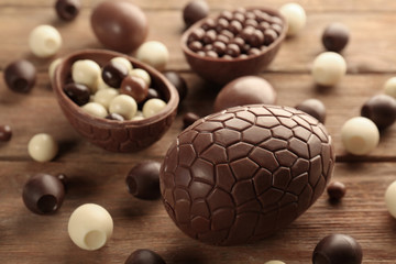 Chocolate Easter eggs and sweets on brown wooden background