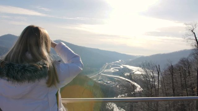 skybridge observation deck. Woman enjoing sunlight and scenery view of the mountains