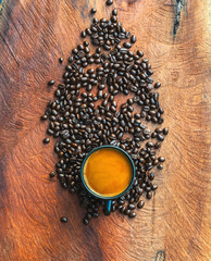 Coffee cup and coffee beans on wood background