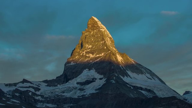 dawn, sunrise time lapse of the amazing matterhorn mountain in the Swiss Alps. the sky lights up in an incredible display of colour followed by the shadow lowering over the mountain