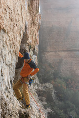 Rock climber ascending a challenging cliff. Extreme sport climbing. Freedom, risk, challenge, success.