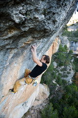 Outdoor activity. Extreme rock climbing lifestyle. Male rock climber on a cliff wall. Siurana, Spain.