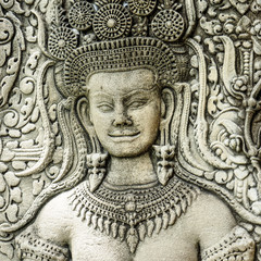 Close up  of face of a stone carving of an angel or Apsara on the wall of Angkor Wat, the 12th...