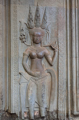 Fototapeta premium Stone carving of an angel or Apsara on the wall of Angkor Wat, the 12th century Hindu temple complex in Cambodia
