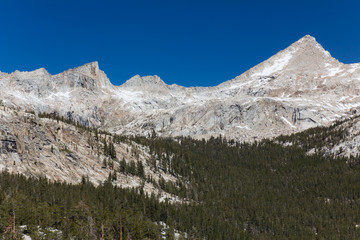 Fototapeta na wymiar Snow covered granite peaks and cliffs during Spring in California's Sierra Nevada mountains