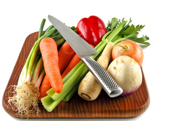Vegetables on a chopping board with a knife ready for preparation