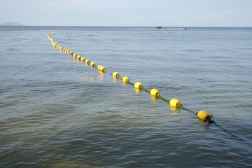 yellow buoy line floating on the water.