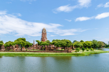 Fototapeta premium Main tower of Wat Phra Ram monastery and surrounding lake, in Ayutthaya Historical Park, Thailand. The park is now a UNESCO world heritage site. 