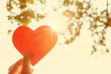 Hand holding paper heart.  Instagram effect.
