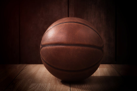 Vintage basketball on a wooden court background in the spotlight