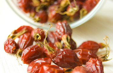 Dried rosehips scattered on the wooden table