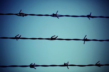 three barbed  wire lines and light blue background