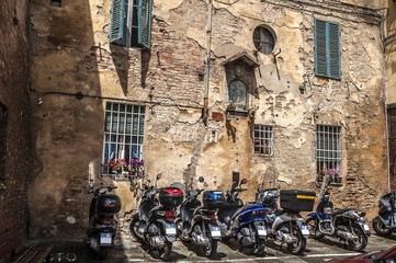 Motor scooter on the medieval street of Siena./Siena is a city in the Italian region of Tuscany, the administrative center of the homonymous province. Motor scooter on themedieval street.