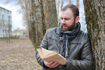 man read book tree park