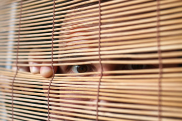 Naklejka premium eyes looking through the blinds