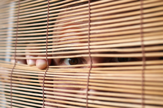 eyes looking through the blinds