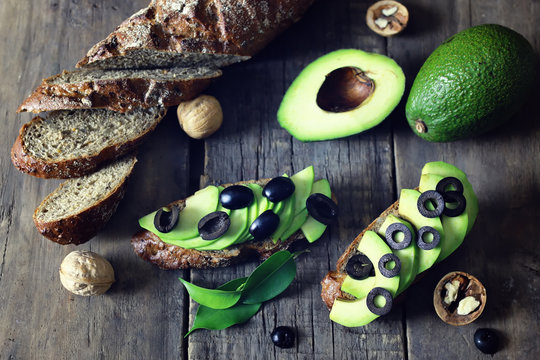 avocado bread olives on a wooden background