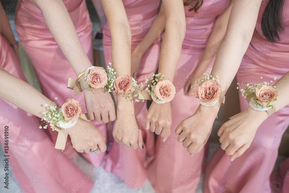 Wall mural close up of hands bridesmaid with flower and pink dress - Wall murals