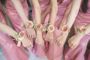close up of hands bridesmaid with flower and pink dress - obrazy, fototapety, plakaty