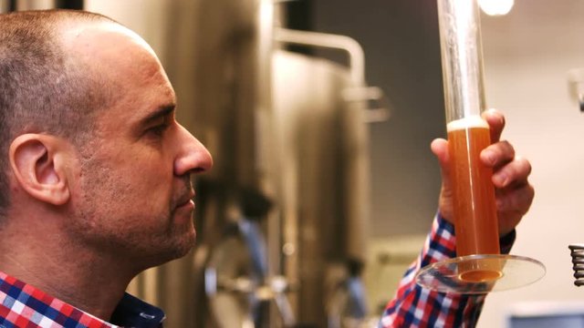 Female brewer holding hydrometer cylinder