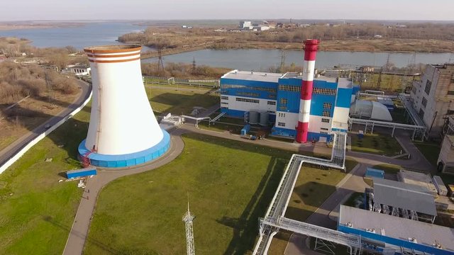 Modern thermal power station with a large cooling tower near the river. Russia. 4K