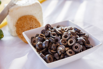 olives cut into rings on the table with bread and cheese