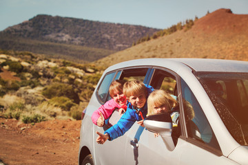 happy mother with two kids travel by car in nature