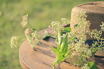 straw hat on a wooden table in a forest