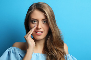 Beautiful girl with long wavy hair whispers.